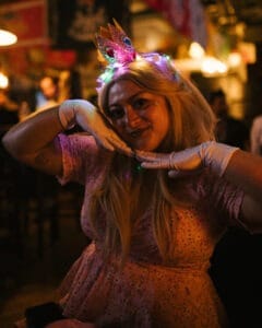 Girl wearing a colorful unicorn headband at a festive event.