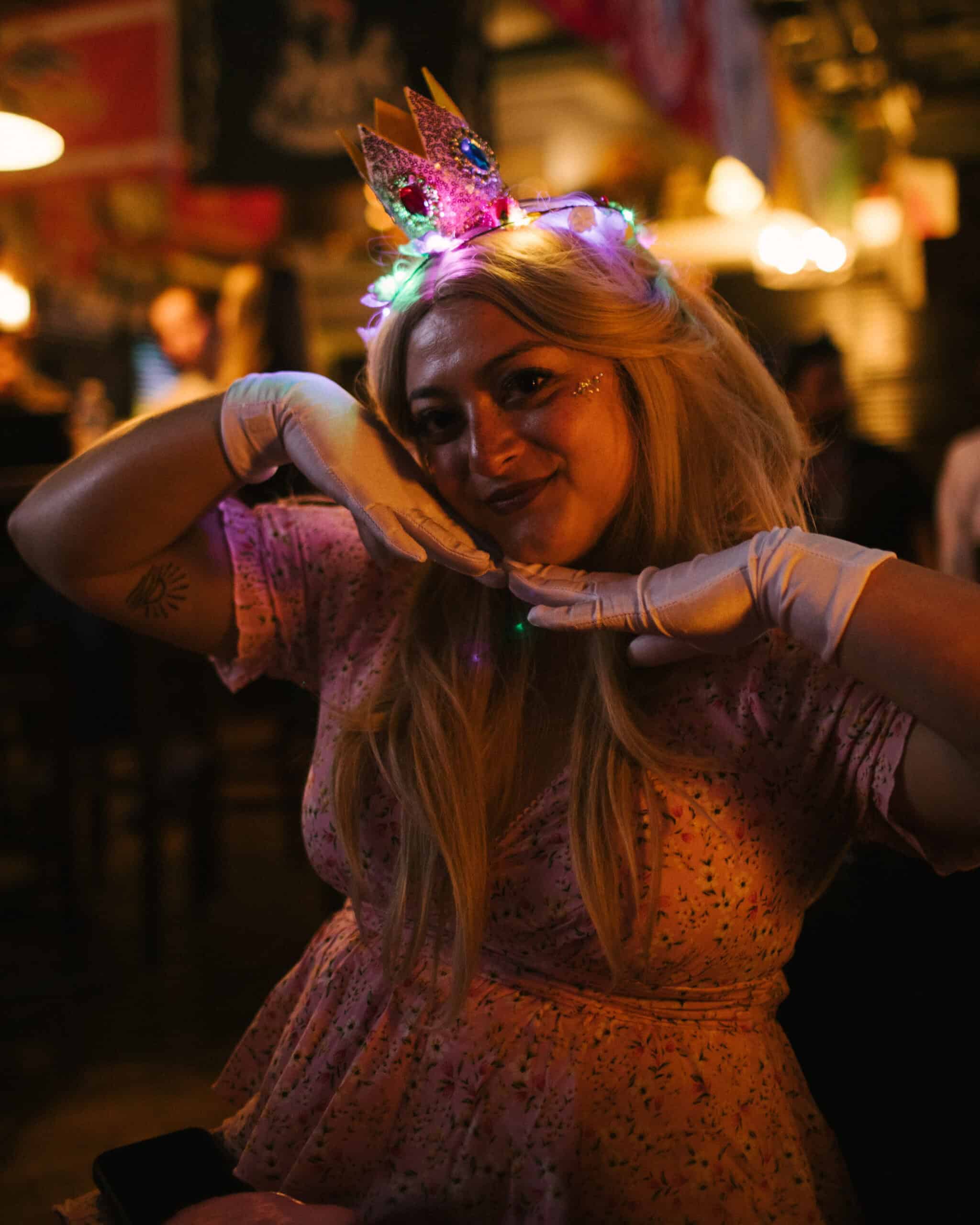 Girl wearing a colorful unicorn headband at a festive event.