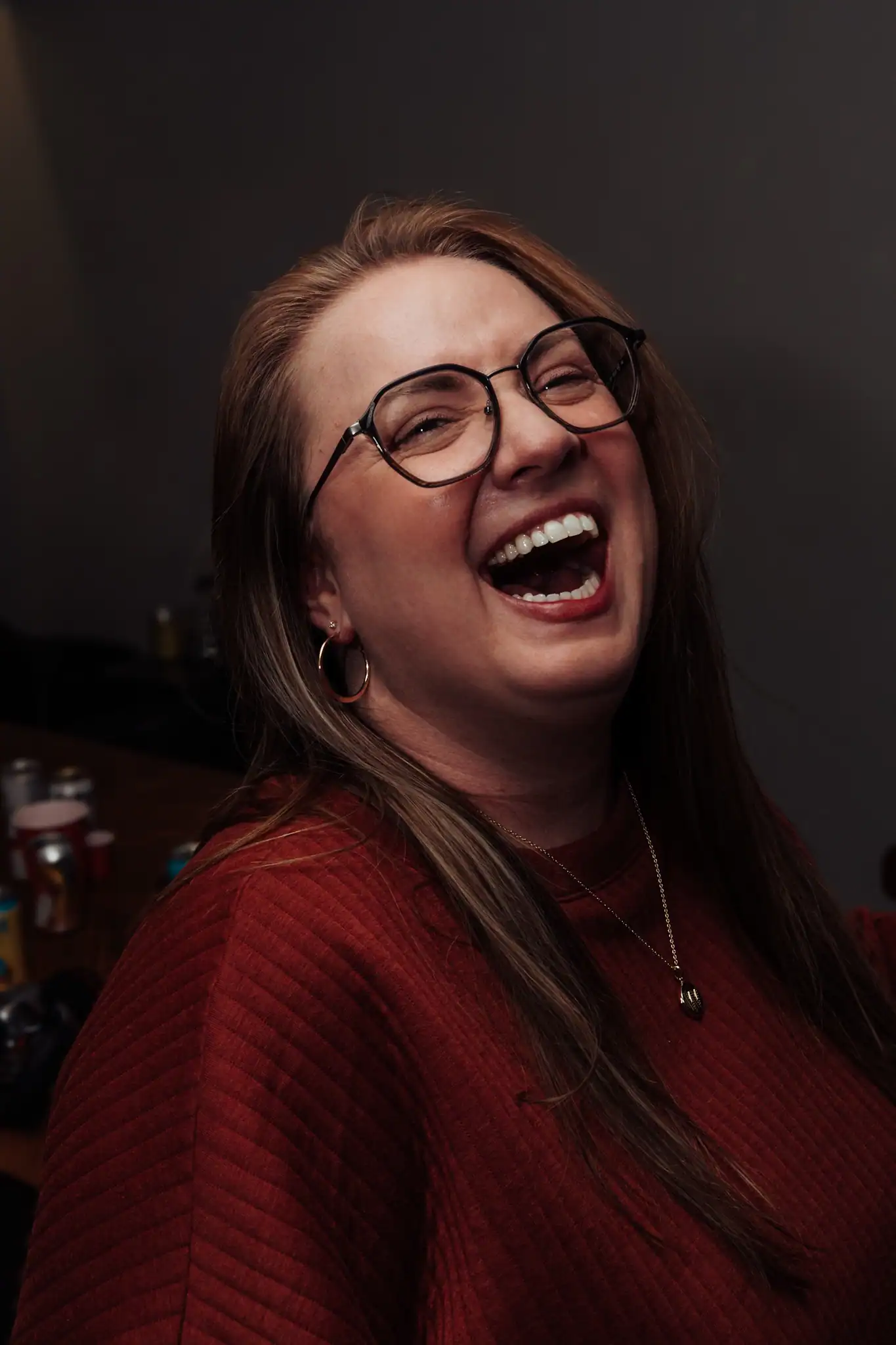 Happy woman with glasses laughing joyfully at a photography session.