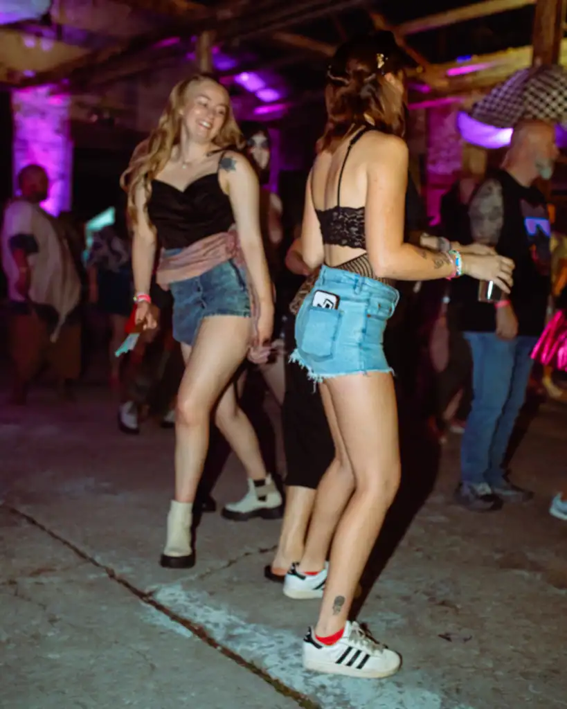 Group of young women dancing at a lively indoor event.