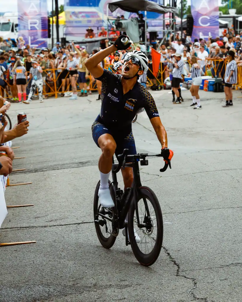 Cyclist raising his arm in celebration at a street race finish