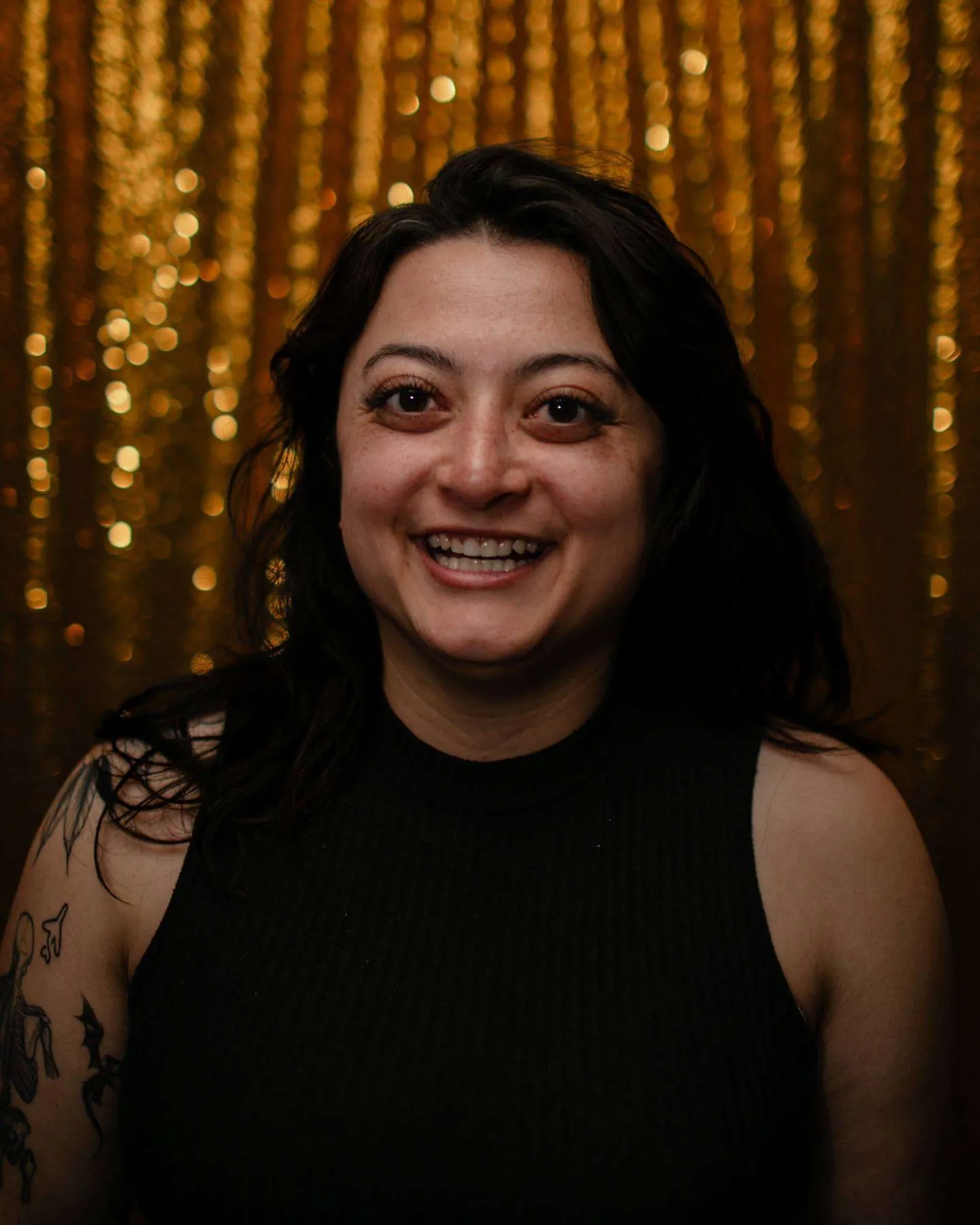 Smiling woman photographed against a gold backdrop